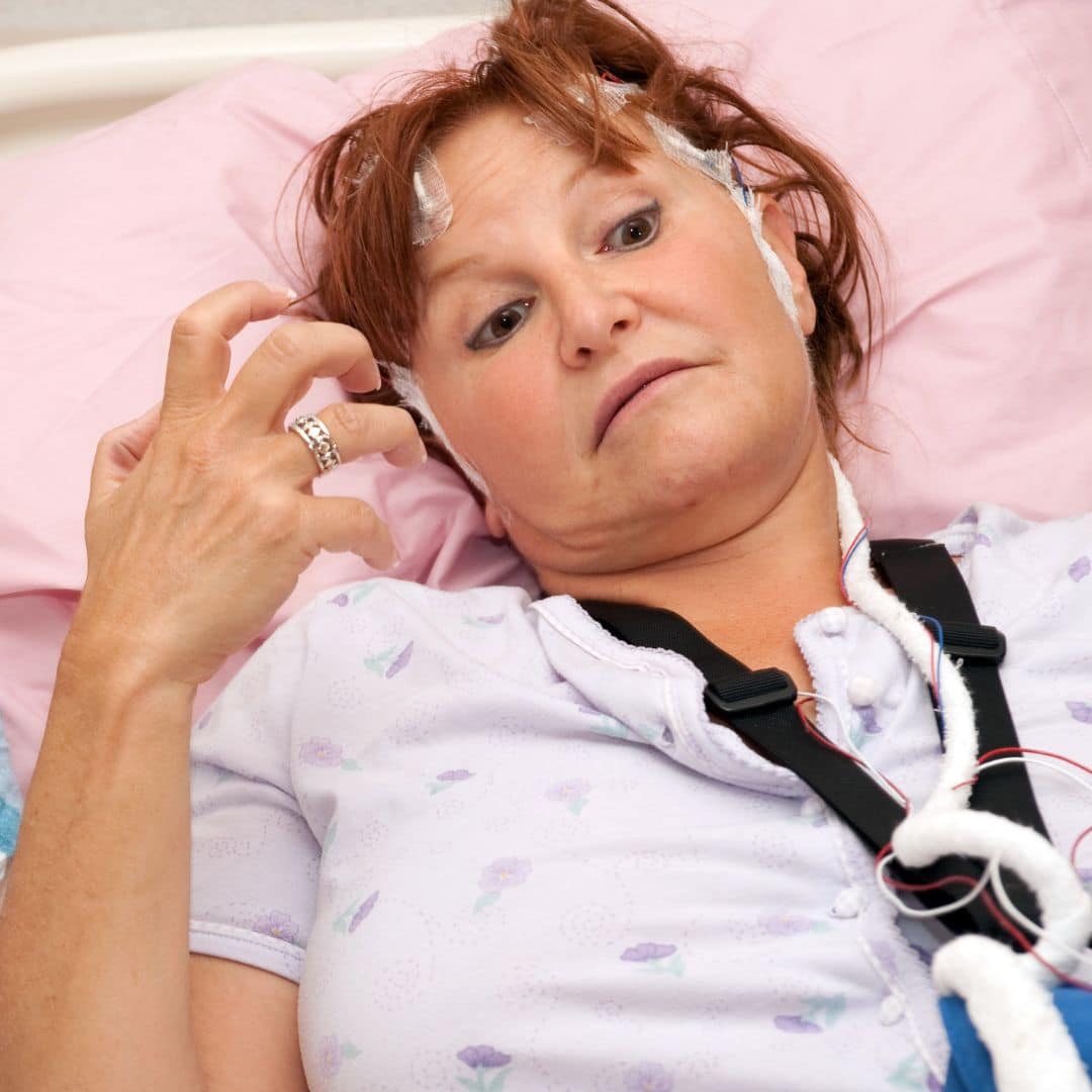 woman lying in bed with electrodes
