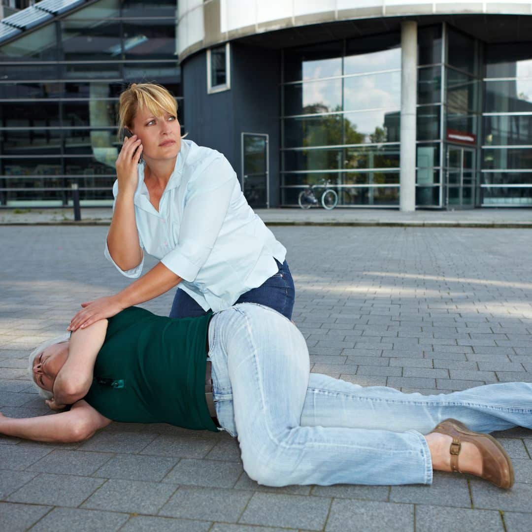 woman consoling a woman having a seizure