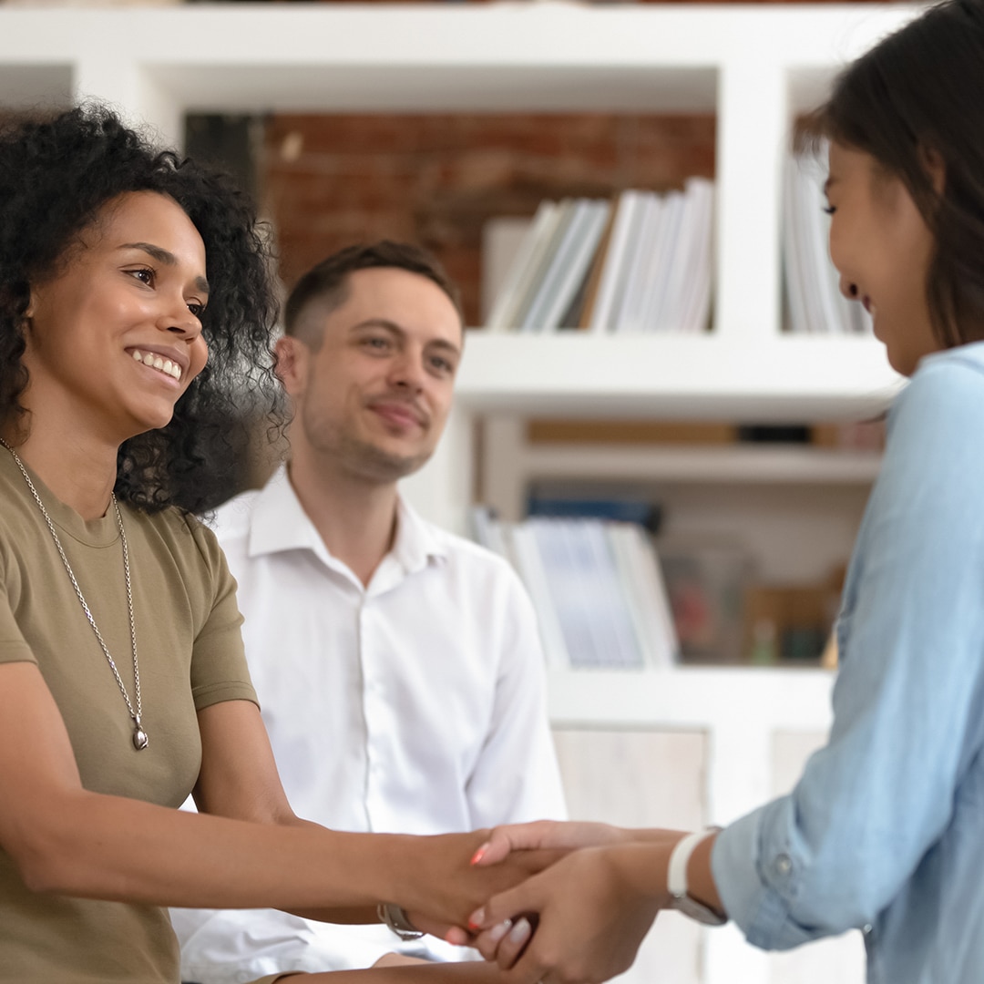 Women shaking hands at a group meeting
