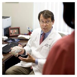 Doctor holding plastic brain with patient