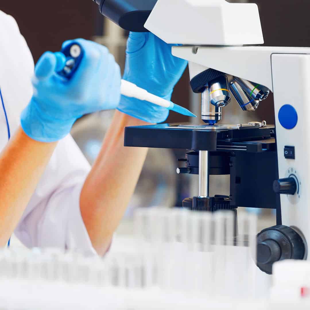 Technician placing a DNA sample on a microscope slide