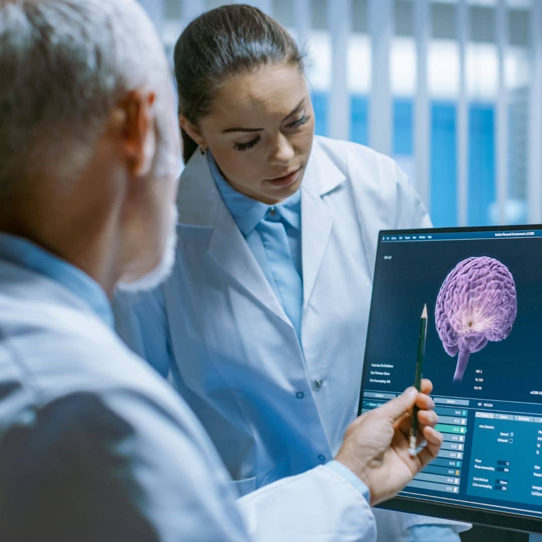 doctors looking at a brain scan on the computer