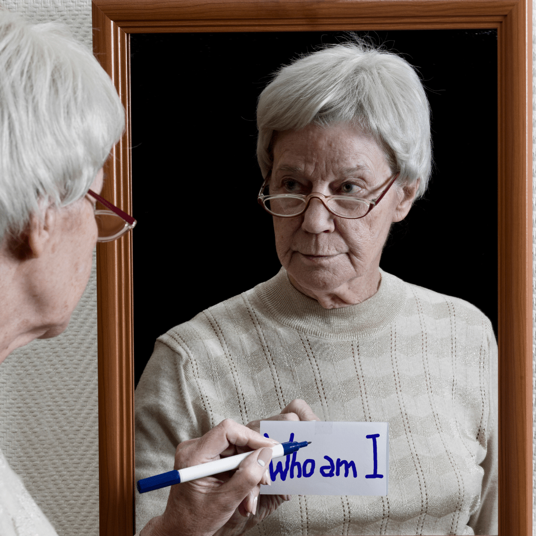An older woman write who am I on her mirror