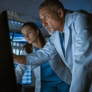 two neurologists looking and pointing at a scan